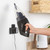 Handheld vacuum being placed on wall-mounted charger in modern kitchen