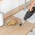 Handheld vacuum cleaning crumbs on kitchen counter