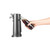 Hand holding glass bottle under black electric bottle opener
