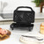 Black sandwich toaster open on kitchen counter