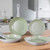 Set of four light green non-stick frying and grill pans on kitchen counter