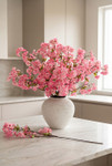Faux plum blossom branches arranged in neutral vase on marble countertop in modern kitchen setting – ShopWildThings.com