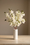 Extra full ivory artificial cherry blossom branches arranged in white ceramic cylinder vase on stone tabletop, ShopWildThings.com event floral decor