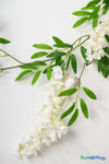 Close-up of artificial smilax willow leaf and white wisteria garland from ShopWildThings.com, realistic faux greenery for weddings