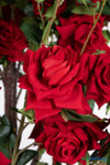 Red artificial rose flower close up showing layered fabric petals and realistic floral craftsmanship