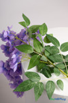 Detailed view of realistic green leaves and lavender wisteria flowers on a 45 inch artificial cascading floral spray from ShopWildThings.com