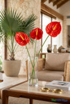 Three Real Feel Red Anthurium Tropical Stems arranged in a tall glass cylinder vase on a table in a luxury resort lounge setting