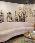 Boutique interior display featuring the ShopWildThings 6-foot Adalee Flowering Cherry Blossom Tree in blush pink, styled in a retail setting with soft neutral tones and gold accents. This artificial tree provides a romantic focal point near the checkout area and is fully compatible with the ShopWildThings Interchangeable Replacement Branch system, allowing boutique owners to refresh their look seasonally with ease.