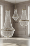 Tillie crystal clear acrylic beaded empire chandeliers in Extra Large, Large, and Medium sizes displayed in a refined neutral interior, highlighting tiered faceted bead strands and ornate matte taupe metal detailing.