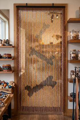 Dog bone wooden bead curtain, 35.5 inches wide by 6.5 feet long, featuring 65 strands of natural wood beads framed in dark brown border.