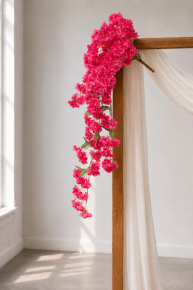 41" Beauty Pink Cascading "Spring Blossom" Spray – Extra-Full Silk Floral Waterfall from ShopWildThings.com styled on a simple wooden wedding arch with white draping, natural window light, and cascading pink floral branches for ceremony decor.