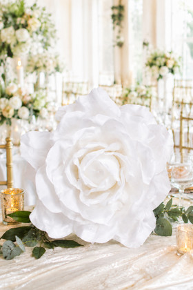 White Silk XXXL Rose Head used as an oversized wedding table centerpiece with elegant candles, greenery and event décor from ShopWildThings.com.