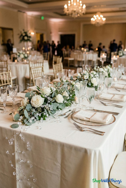 Clear crystal bead vine garland with faceted acrylic crystals on silver wire, styled as elegant wedding table décor