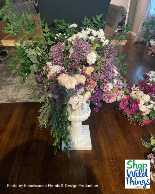 Create Bridgerton inspired floral arrangements with ShopWildThings.com! We have everything you need to get the look- Urns and Columns, plus over 600 Greenery Branches, plus a wide collection of Artificial Silk Floral Sprays, Stems, Branches, Garlands, and more!
Based out of Arizona, we have a wonderful team that can help you get the look you are going for- and get it delivered fast. 
Bridgerton Urn Pedestal Floral Arrangements with Silk Flowers and Greenery Sprays for Spring Weddings
