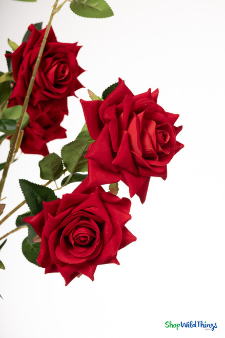 34-inch red velvet artificial rose branch with 12 open roses and 3 buds, shown against a white background with bendable stems and lifelike green leaves.