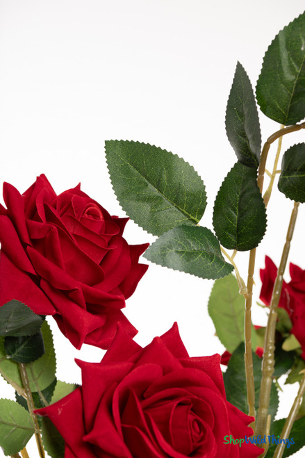 34-inch red velvet artificial rose branch with 12 open roses and 3 buds, shown against a white background with bendable stems and lifelike green leaves.