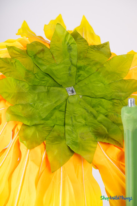 Back view of oversized artificial sunflower bloom showing green leaves and attachment hardware on 44" silk sunflower – ShopWildThings photo prop.