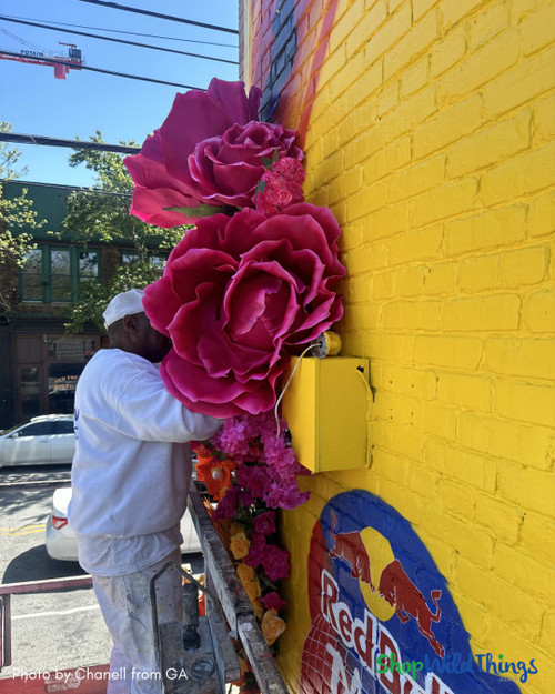 Fuchsia Pink Jumbo Roses by ShopWildThings.com in this outdoor mural!  While our giant florals are designed for indoor use (and treated with UV protectant spray), this project is pure inspiration.  
Shop our collection to bring big blooms to your home, office, spa, or any place that needs some cheering up. Our ready to use Giant Roses and Peonies have been selling fast, so order yours today!