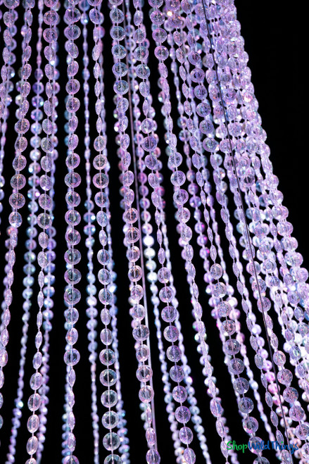 Macro detail of iridescent diamond crystal bead strands on Belvedere chandelier reflecting purple and blue event lighting