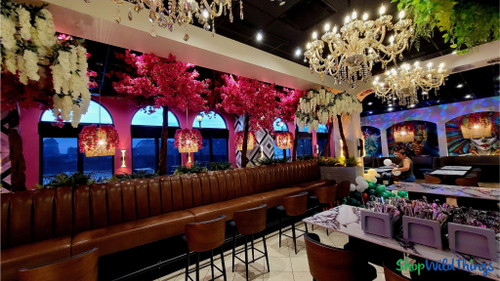 Fuchsia pink artificial bougainvillea floral ceiling installation using ShopWildThings Sideswept Trees with interchangeable replacement branches, designed as a statement decor element in a luxury restaurant dining area