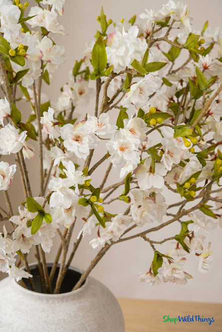 ShopWildThings artificial cherry blossom arrangement close-up showing ivory blooms green leaves and realistic detail