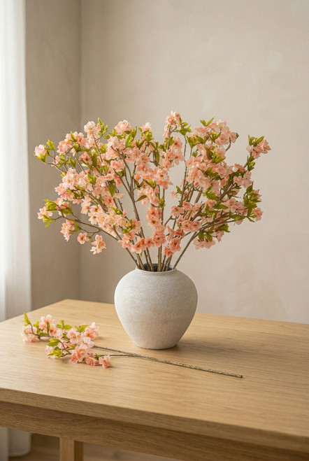ShopWildThings artificial pink cherry blossom arrangement in white ceramic vase on wood table in warm minimal interior