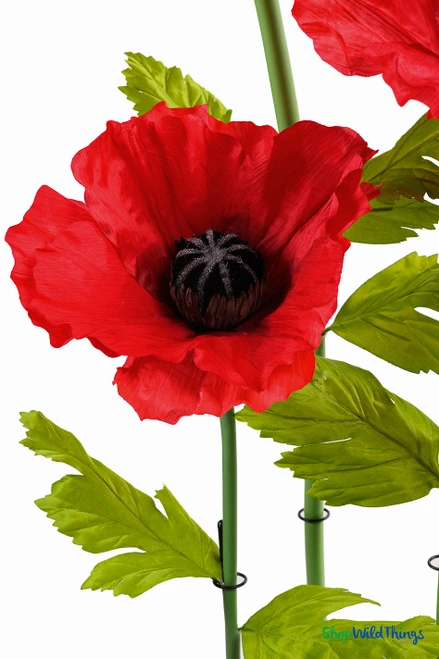Detailed view of ShopWildThings.com Oversized Large Silk Poppy Bloom with textured red petals, black flower center, and bright green leaves for lifelike effect.