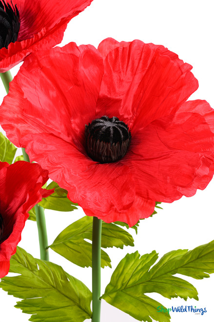 Detailed view of ShopWildThings.com Oversized Large Silk Poppy Bloom with textured red petals, black flower center, and bright green leaves for lifelike effect.