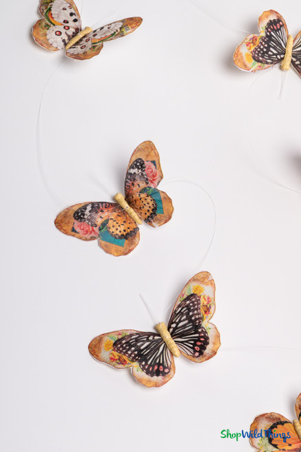 Rustic orange and tan feather butterfly garland, featuring hand-painted butterflies with floral details, displayed against white backdrop.