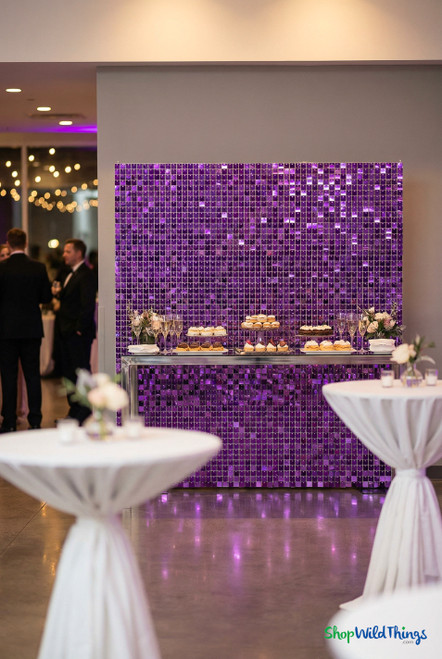 Purple shimmer sequin wall panels installed as a full backdrop at an upscale event, creating a sparkling photo wall and dessert display background using modular shimmer panels from ShopWildThings.com