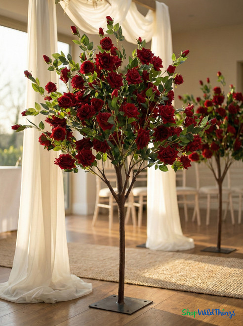 Full artificial red rose tree centerpiece used for wedding aisle décor with lush blooms and realistic greenery