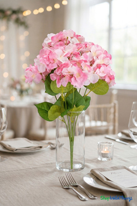 Pink and white hydrangea bush centerpiece in clear glass vase on elegant event table setting – ShopWildThings.com
