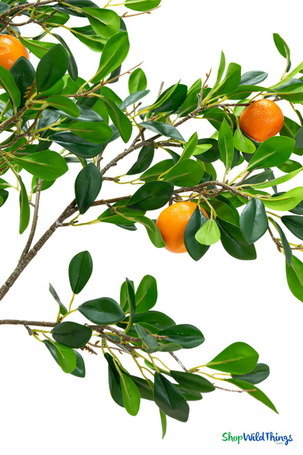 Artificial citrus branch detail showing bright orange fruit and layered green leaves, high realism product photo