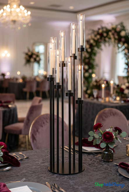 Black Stem Cluster 42 inch tall candelabra with 8 glass hurricane cylinders and ivory taper candles styled on an upscale event table from ShopWildThings.com