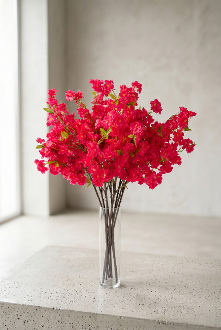 40" Artificial Fuchsia Cherry Blossom Branch – Vivid Spring Flowering Stem for Event Decor from ShopWildThings.com arranged in a clear cylinder vase as a full bright pink cherry blossom bouquet in soft natural light