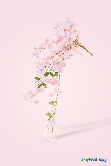 41" Beauty Pink Cascading "Spring Blossom" Spray – Extra-Full Silk Floral Waterfall from ShopWildThings.com shown as a full cascading faux floral spray with soft pink blossoms, bendable brown stems, green leaves, and a pale pink studio background.