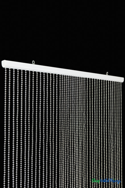 Silver acrylic ball chain curtain with 45 strands used as event backdrop behind sweetheart table with warm uplighting