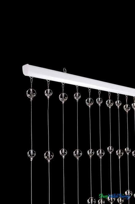 Close-up of white header rod and clear round acrylic ball strands on 3' x 6' beaded curtain – ShopWildThings.com