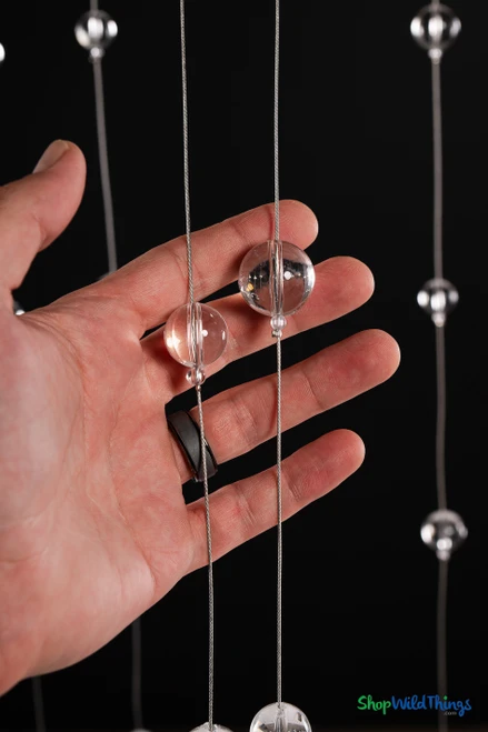 Close-up of two clear acrylic sphere sizes on steel wire from Clear Round Spheres Acrylic Ball Beaded Curtain – ShopWildThings.com