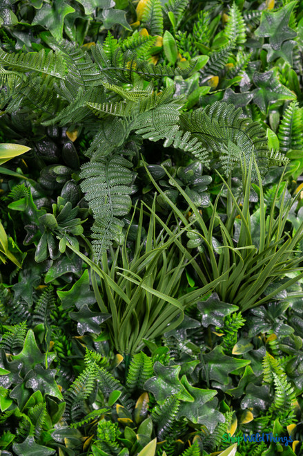Close up of high density artificial greenery wall mat showing realistic ferns ivy grasses and layered foliage textures – 2" to 7" depth – FR Class C fire treated backdrop panel