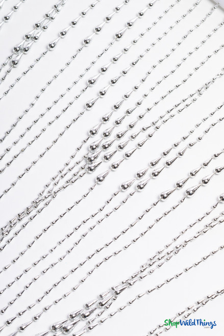 Angled flat lay of silver acrylic raindrop beads attached to scalloped beaded curtain strands – ShopWildThings