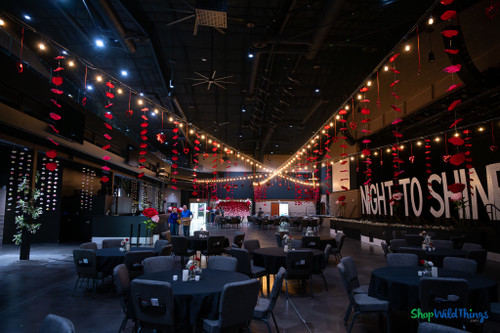 Statement Hanging Ceiling Decor with Lightweight Huge Rose Petals by ShopWildThings.com
Create romantic, high-impact wedding décor with our Set of 3 Red Silk Rose Petal Garlands. Designed for professional event designers, wedding planners, venues, and decorators, these generously sized floating petals add scale and movement to large ceremony and reception spaces.

When decorating expansive venues, smaller décor elements can disappear. These substantial silk rose petals provide bold color, dimension, and visual presence — without overwhelming your design.

Perfect for weddings, Valentine’s events, romantic backdrops, bridal showers, and upscale celebrations.

Product Specifications

Set Includes: 3 Individual Garland Strands

Total Combined Length: 16.5 Feet

Individual Strand Length: 66" (5 Feet 5 Inches)

Garland Width: 7.5" Wide

Total Petals: 30 Silk Petals (10 per strand)

Individual Petal Size: 6" Wide x 7.5" Long

Material: Premium Silk Fabric

Stringing Material: Clear, nearly invisible monofilament line

Hanging Loops: Pre-attached on both ends

Storage: Collapses flat into included resealable storage bag

The three strands can be connected to form one continuous 16½-foot garland or styled individually for layered installations.

Designed for Weddings & Large Event Spaces

These silk rose petal garlands are specifically designed to provide visible scale in large ballrooms, outdoor ceremonies, churches, and reception halls.

The variegated red petals create a soft, floating floral effect that photographs beautifully and enhances both indoor and outdoor installations.

Lightweight yet visually impactful, they install in seconds and store easily for reuse — making them ideal for event professionals managing multiple setups.

Versatile Styling Options

These red rose garlands can hang vertically or horizontally and are easy to drape, swag, or wrap.

Popular Uses Include:

Table runners and sweetheart table draping

Ceiling swags and overhead décor

Wedding arches and gazebo accents

Aisle markers on shepherd hooks

Column and pole wraps

Cake table surround décor

Outdoor tree branch installations

Romantic photo backdrops

Bridal showers, anniversaries, birthdays, and garden parties

Their lightweight construction makes them quick to install while maintaining an upscale, romantic aesthetic.

Frequently Asked Questions (FAQ)
How long is each garland strand?

Each individual strand measures 66 inches long (5 feet 5 inches).

What is the total length when all three strands are connected?

When connected end-to-end, the three strands create a continuous garland measuring approximately 16.5 feet long.

How large are the petals?

Each silk petal measures approximately 6 inches wide by 7.5 inches long.

How many petals are included?

There are 30 total petals included — 10 petals per strand.

Can these garlands hang vertically?

Yes. Each strand includes hanging loops on both ends, allowing you to install them vertically, horizontally, swagged, or wrapped around structures.

Are they reusable?

Yes. The petals collapse flat and store inside the included resealable bag, making them perfect for repeat event use.

Can they be used outdoors?

Yes, they are suitable for outdoor ceremonies and garden events. We recommend avoiding prolonged exposure to heavy rain or strong winds.

Do you offer other sizes?

Yes. This size is available in multiple colors, and we also offer an extra-large version for even greater visual impact in large venues.

Professional Event Décor You Can Trust

Whether you're designing a romantic ceremony backdrop, enhancing a reception ceiling, or adding dimension to an aisle installation, these red silk rose petal garlands provide the scale, elegance, and flexibility professional event décor demands.

ShopWildThings specializes in high-impact floral décor designed to transform ordinary spaces into unforgettable experiences.