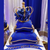 A royal blue tiered birthday cake, fit for a Royal – topped with a Gold Crown Cake Topper by ShopWildThings.com