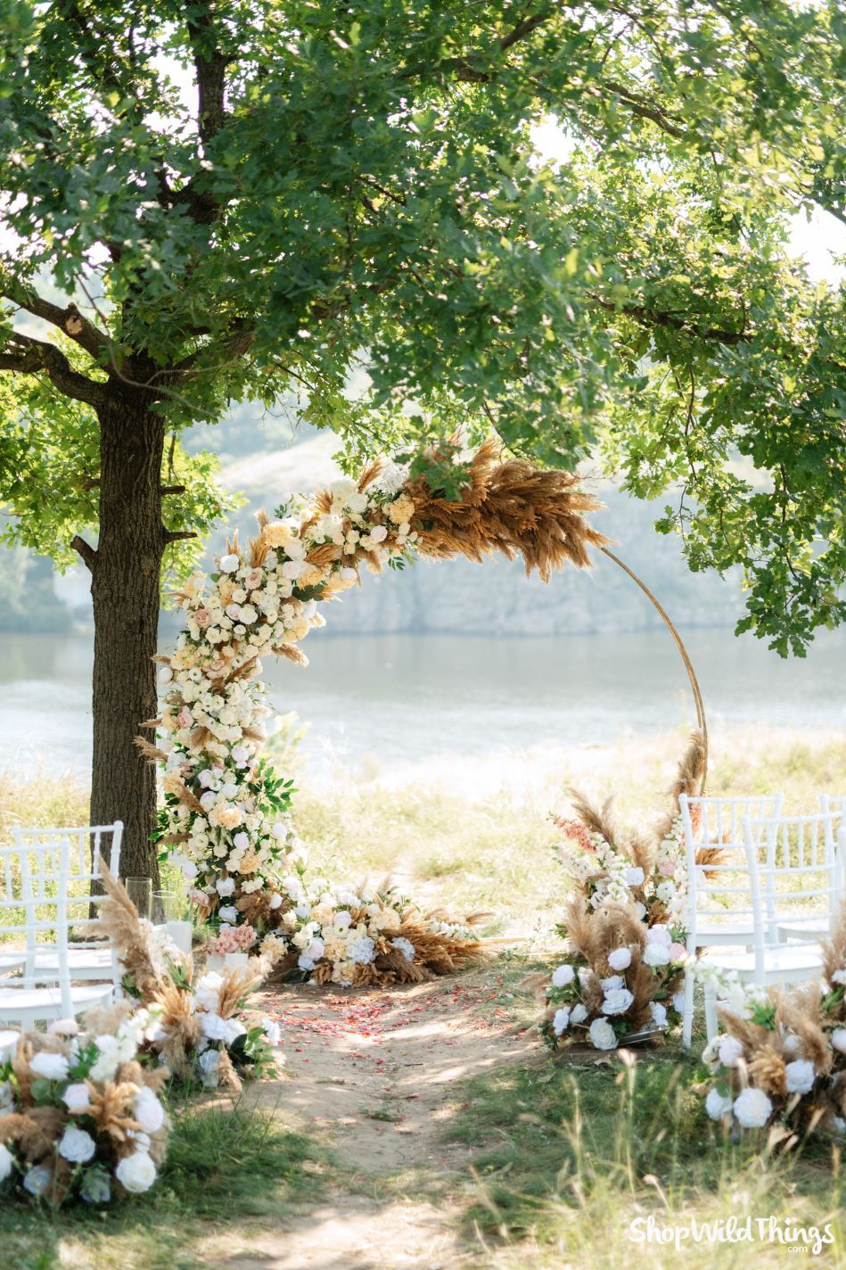 Pampas Grass Wedding Arch Inspiration A gold round arch styled with pampas grass, ivory and peach silk flowers, and lush greenery makes the perfect end-of-summer wedding ceremony backdrop. Pampas grass adds texture and movement, while Artificial Flowers hold up beautifully in the sun. ShopWildThings offers the Artificial Flowers, Pampas Grass, Greenery, and Arches you need to design a ceremony space that feels timeless, romantic, and stress-free.