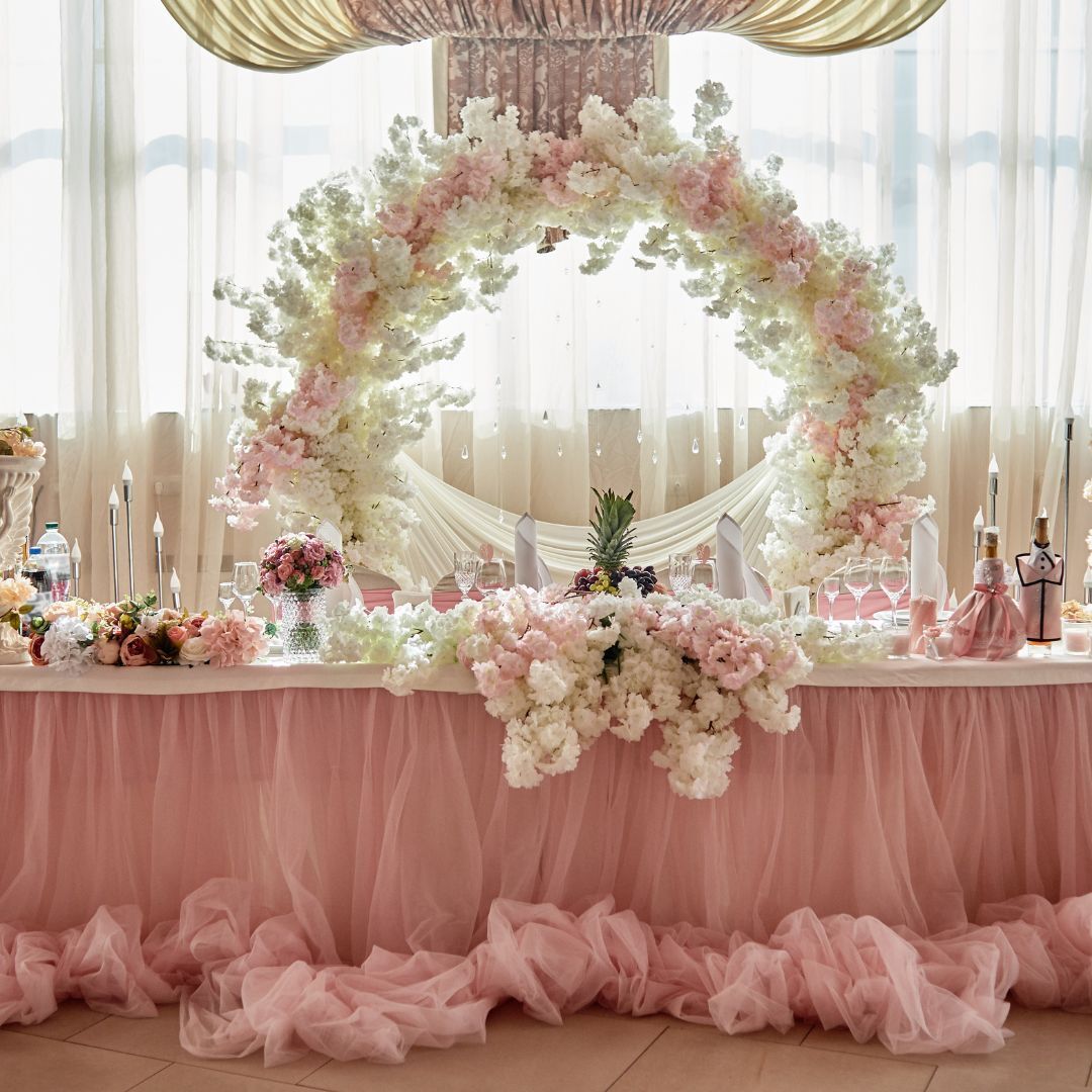 Create a Gorgeous Backdrop Arch with Dogwood and Cherry Blossom Silk Florals in Pinks and Creams and a Round Arch, all available at ShopWildThings.com – Pink and Cream Spring Wedding Reception Head Table Party Decor