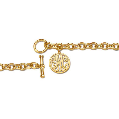 Script monogram cut out letters round charm toggle bracelet in 14K yellow gold.