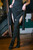 Elven Blade Garter Leggings Black/Green underneath the Huntress Dress, front view with legs crossed
