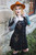 Persephone Mini Dress in black, side view showing flower embroidery, posing with hands near shoulder.