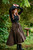 Woman posing with arms above head wearing Forager Skirt in Olive Green with black Ranger Tunic Summer Edition.