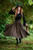 Woman twirling in olive green Forager Skirt paired with Ranger Tunic Summer Edition in black in the woods.